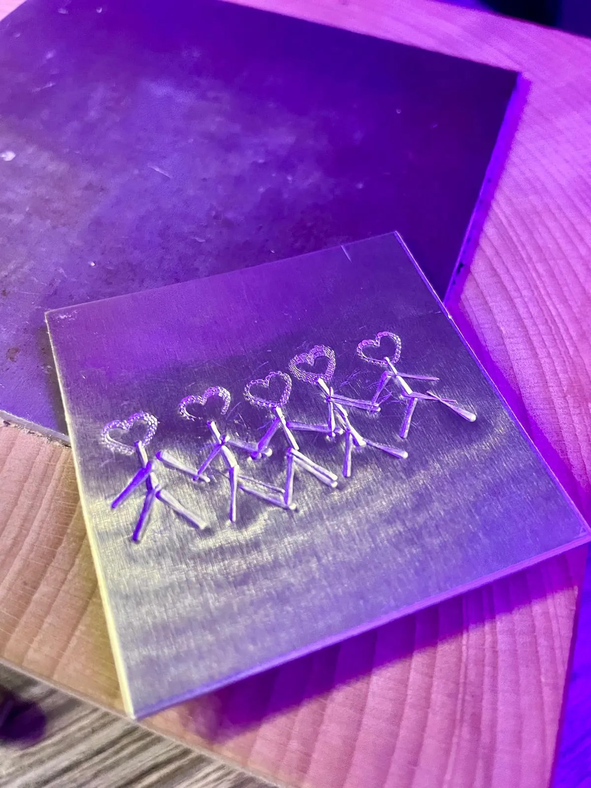 Metallplättchen mit eingehämmerten Symbolen – kleine Figuren und Herzen beim Wortschmiede-Ritual einer freien Trauung
