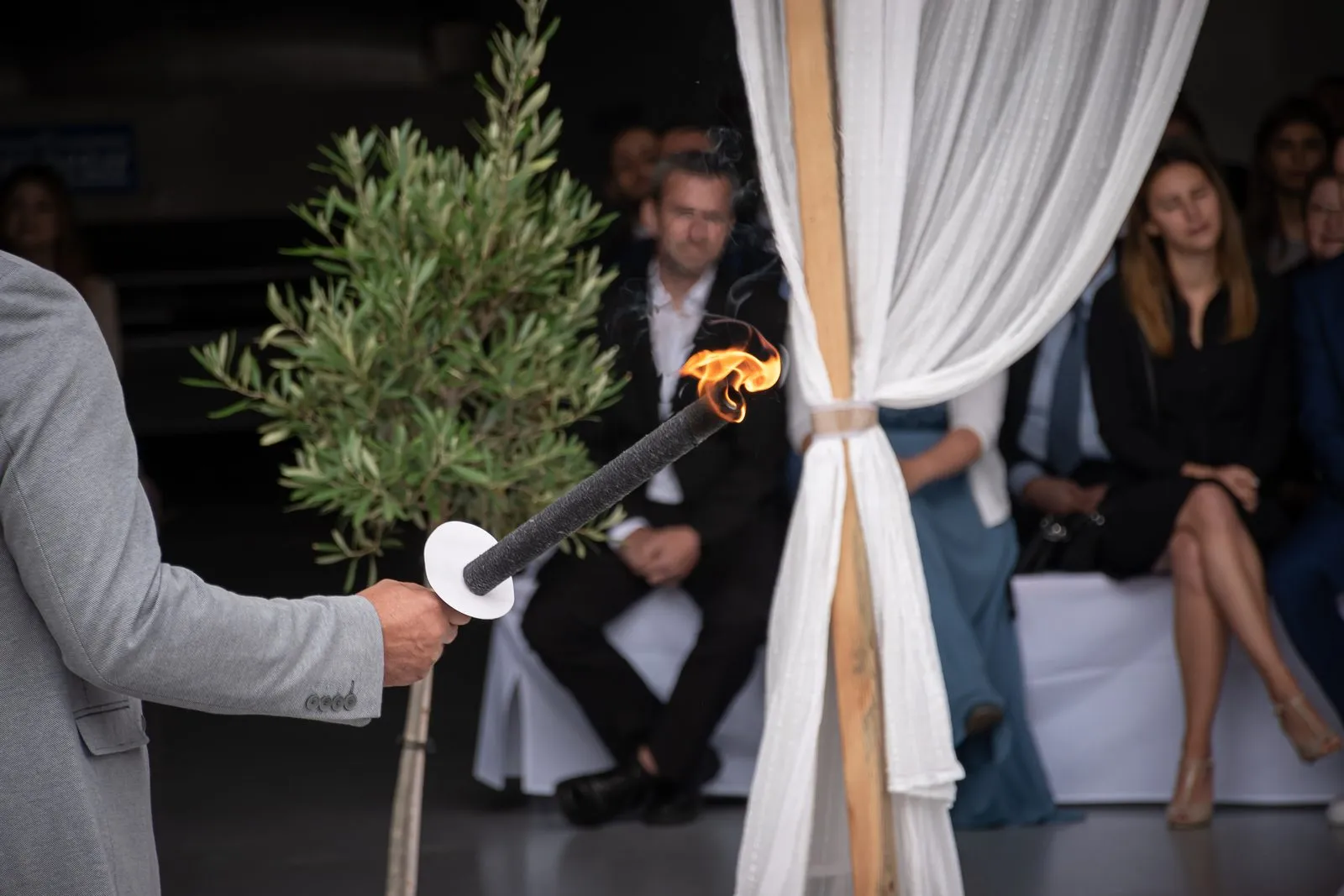 Foto: Lisa Prinzler Entzünden der Fackel beim Feuerritual – die Hochzeitsgesellschaft im Hintergrund bei der freien Trauung