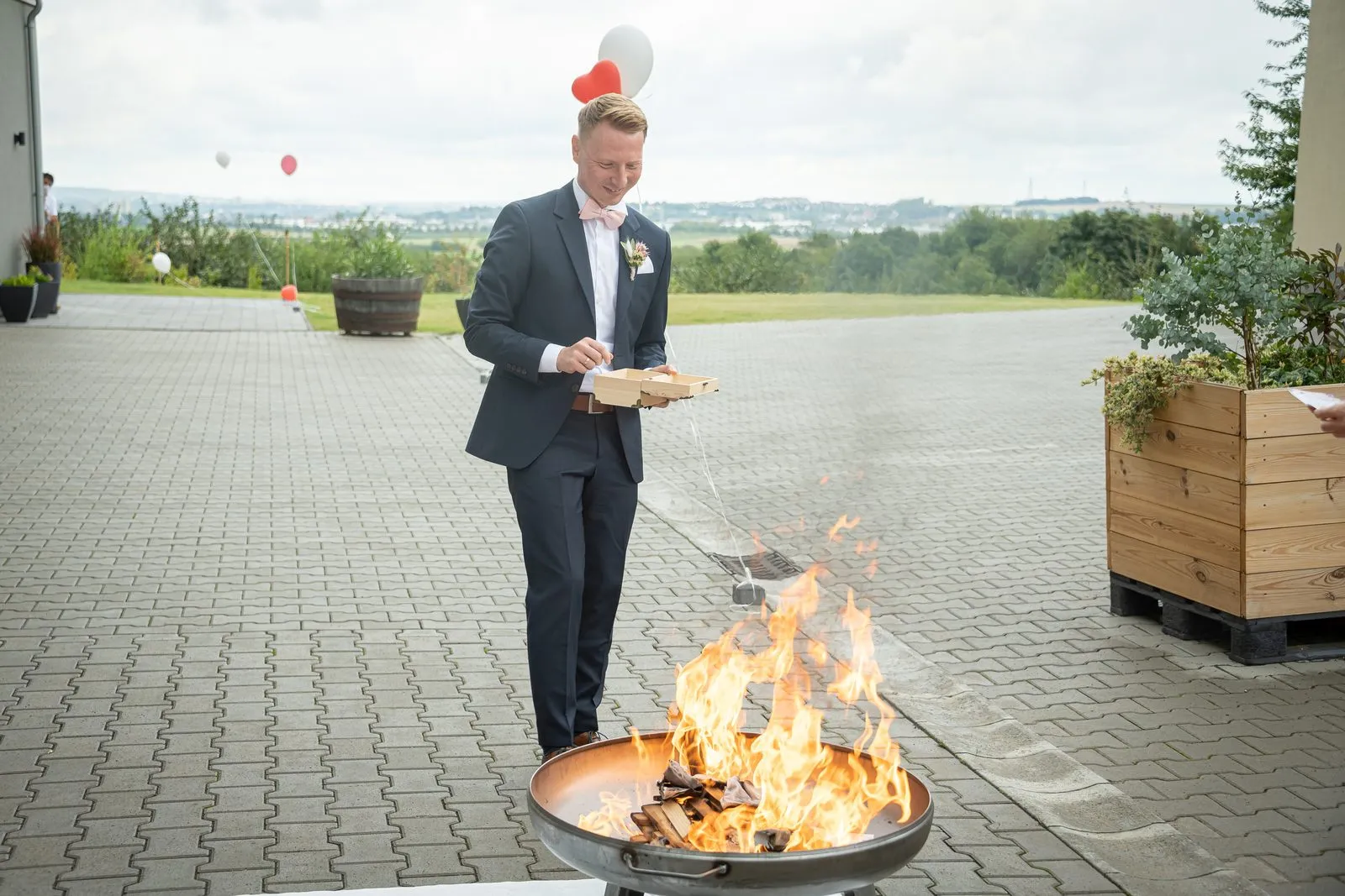 Foto: Lisa Prinzler Bräutigam gibt die Wunschzettel ins Feuer beim Feuerritual, freie Trauung in Rheinhessen