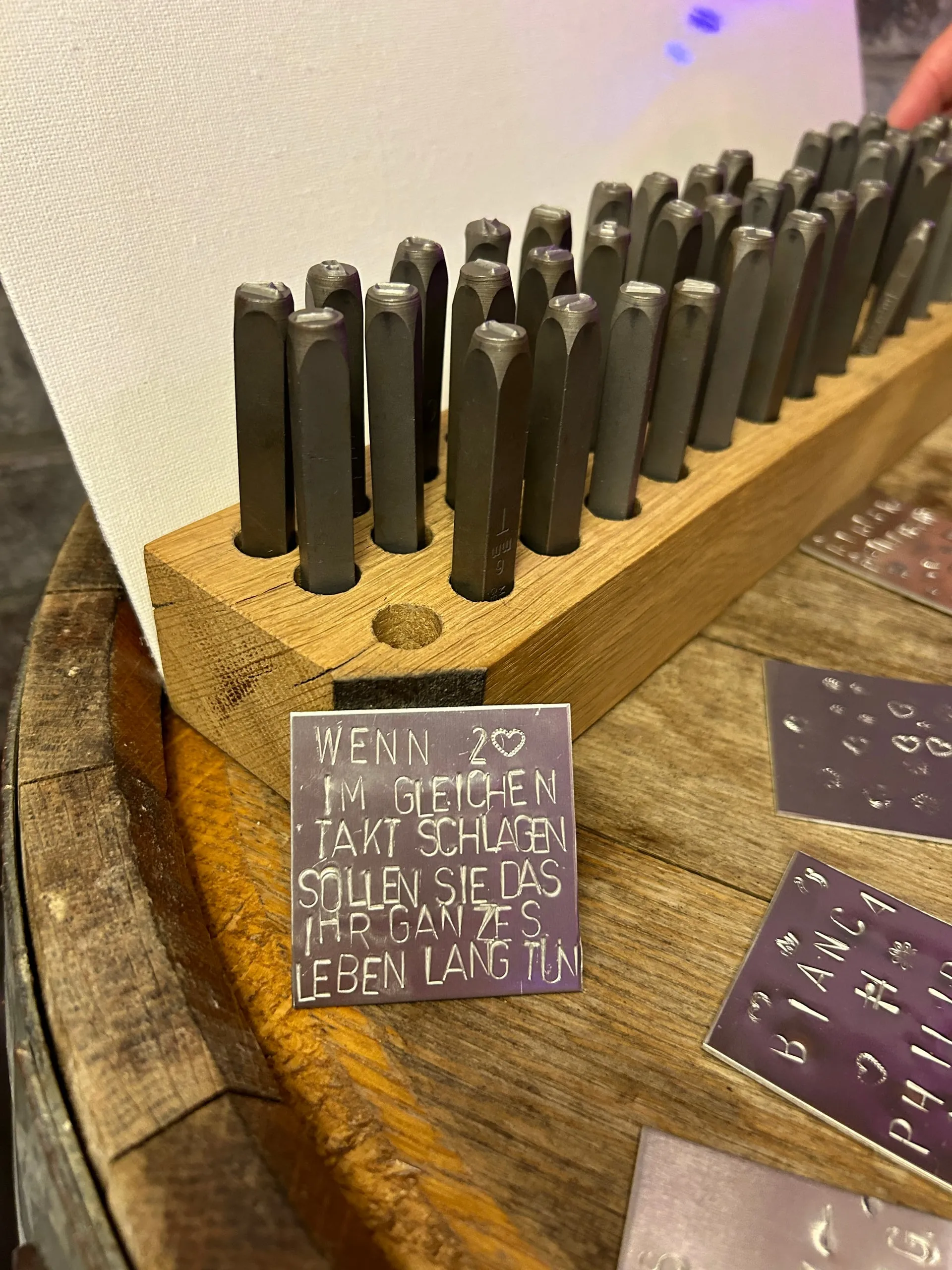 Metallplättchen mit dem eingehämmerten Spruch „Wenn 2 im gleichen Takt schlagen, sollen sie das ihr ganzes Leben lang tun“ beim Wortschmiede-Ritual