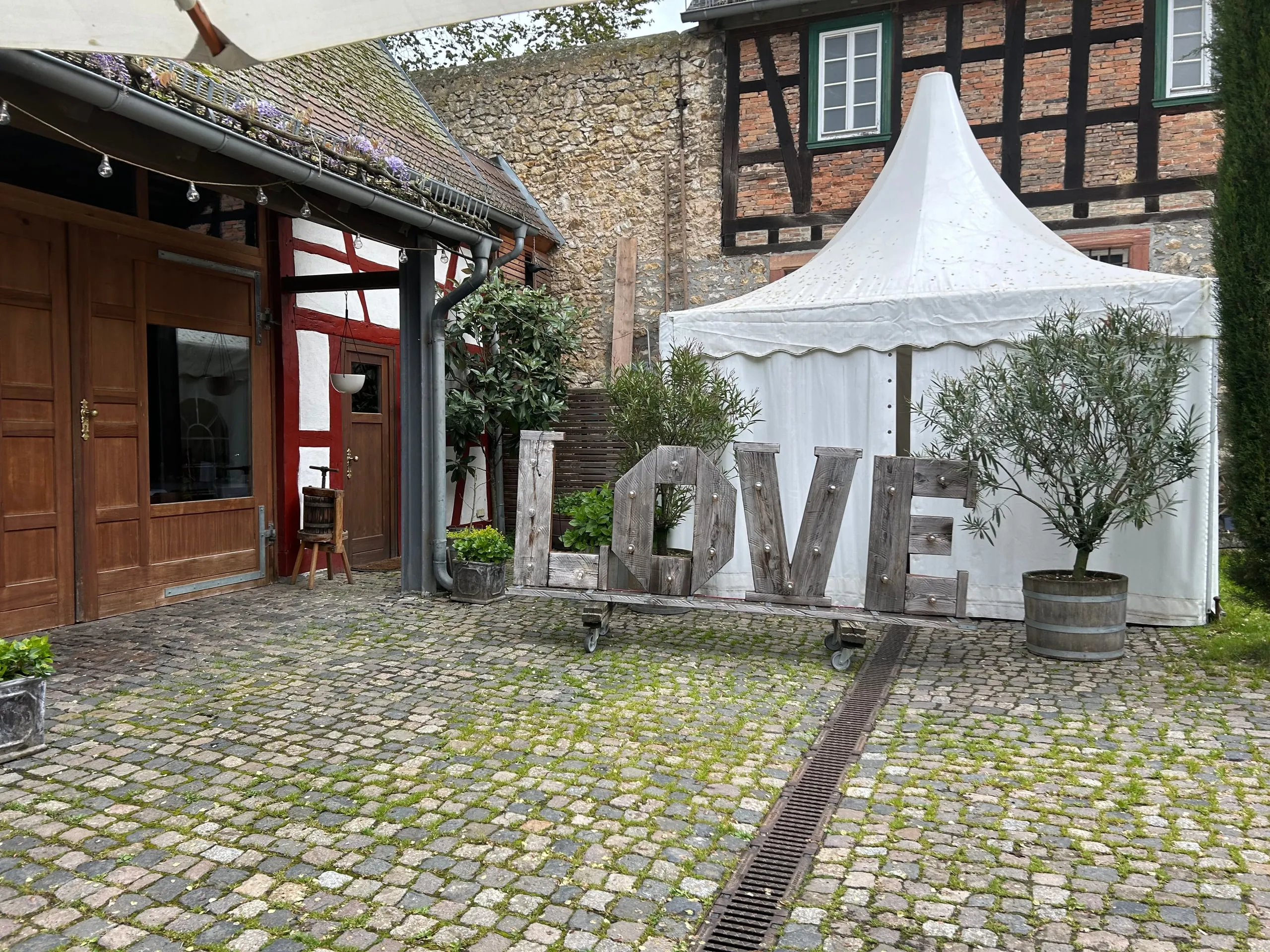 LOVE-Buchstaben im Innenhof vor einem Fachwerkhaus mit Pagodenzelt