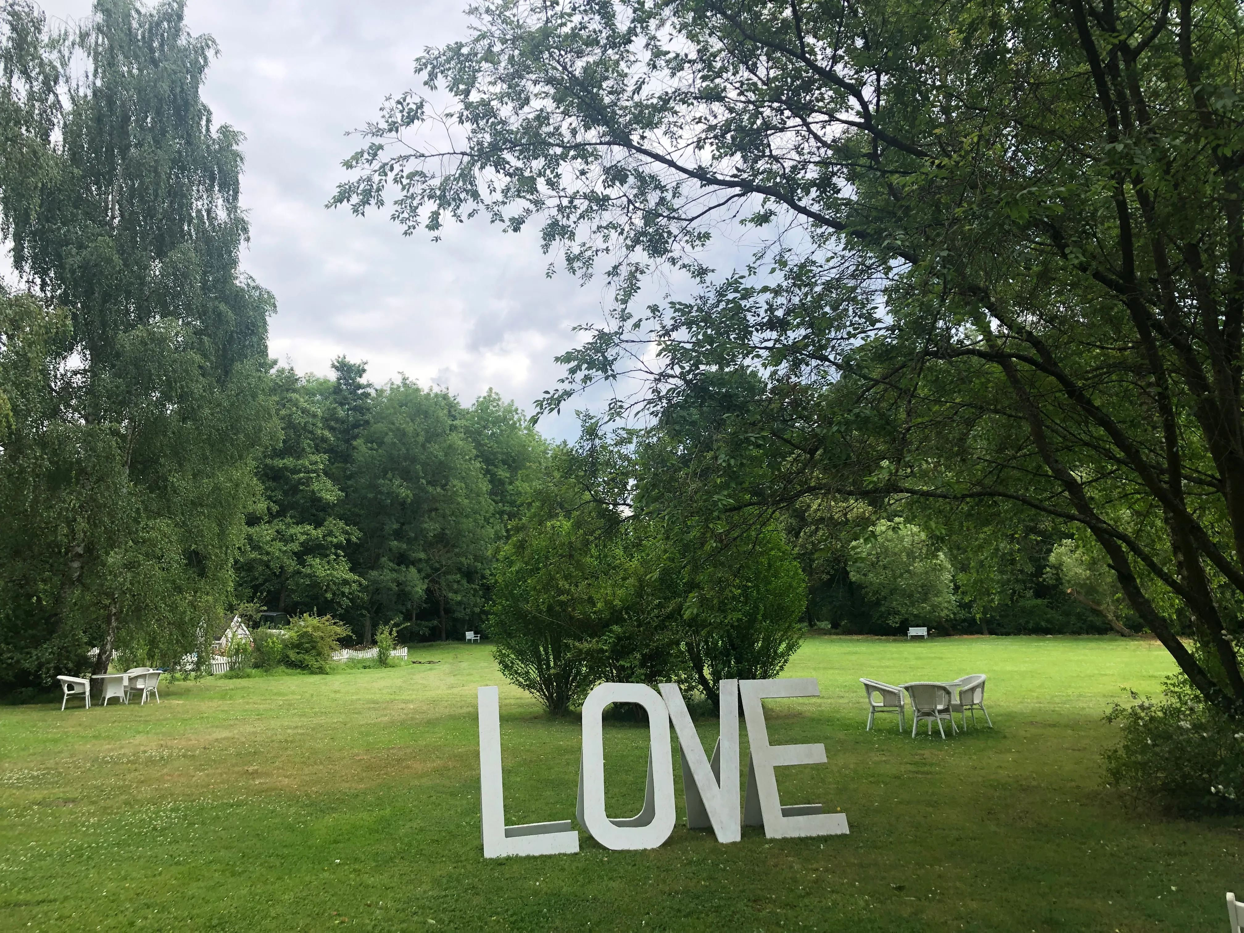 Große weiße LOVE-Buchstaben im grünen Park bei einer Hochzeitsfeier