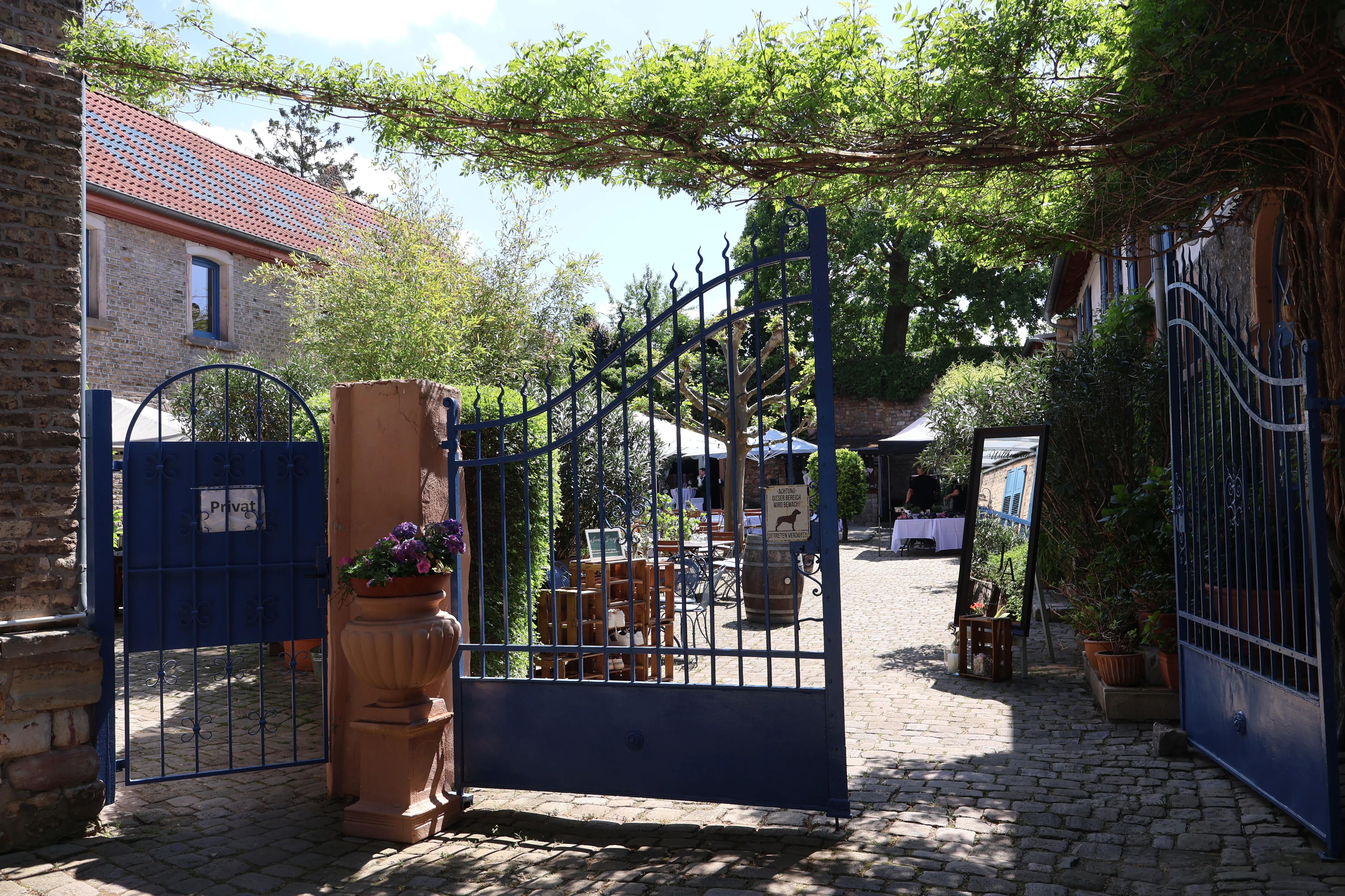 Blick durch das geöffnete blaue Tor in den Innenhof von Wagners Hof Undenheim