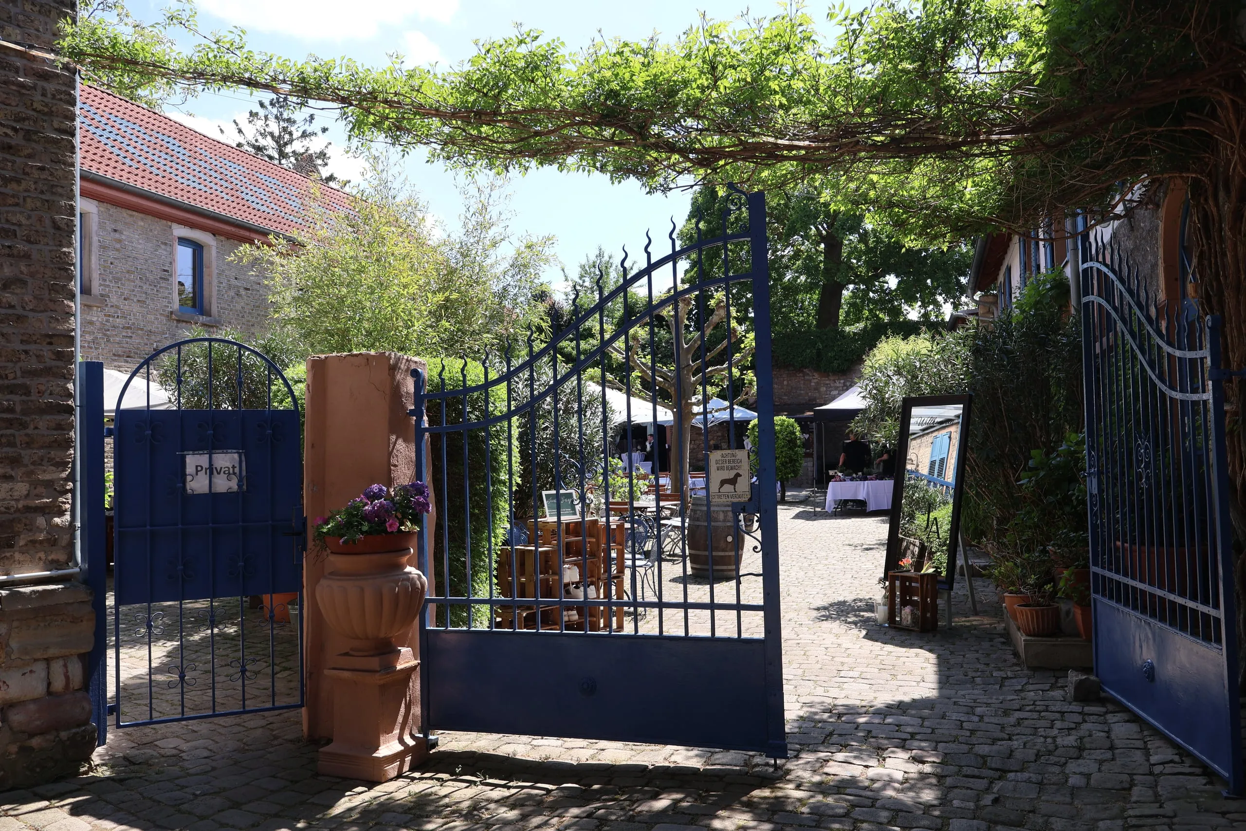 Blick durch das geöffnete blaue Tor in den Innenhof von Wagners Hof Undenheim