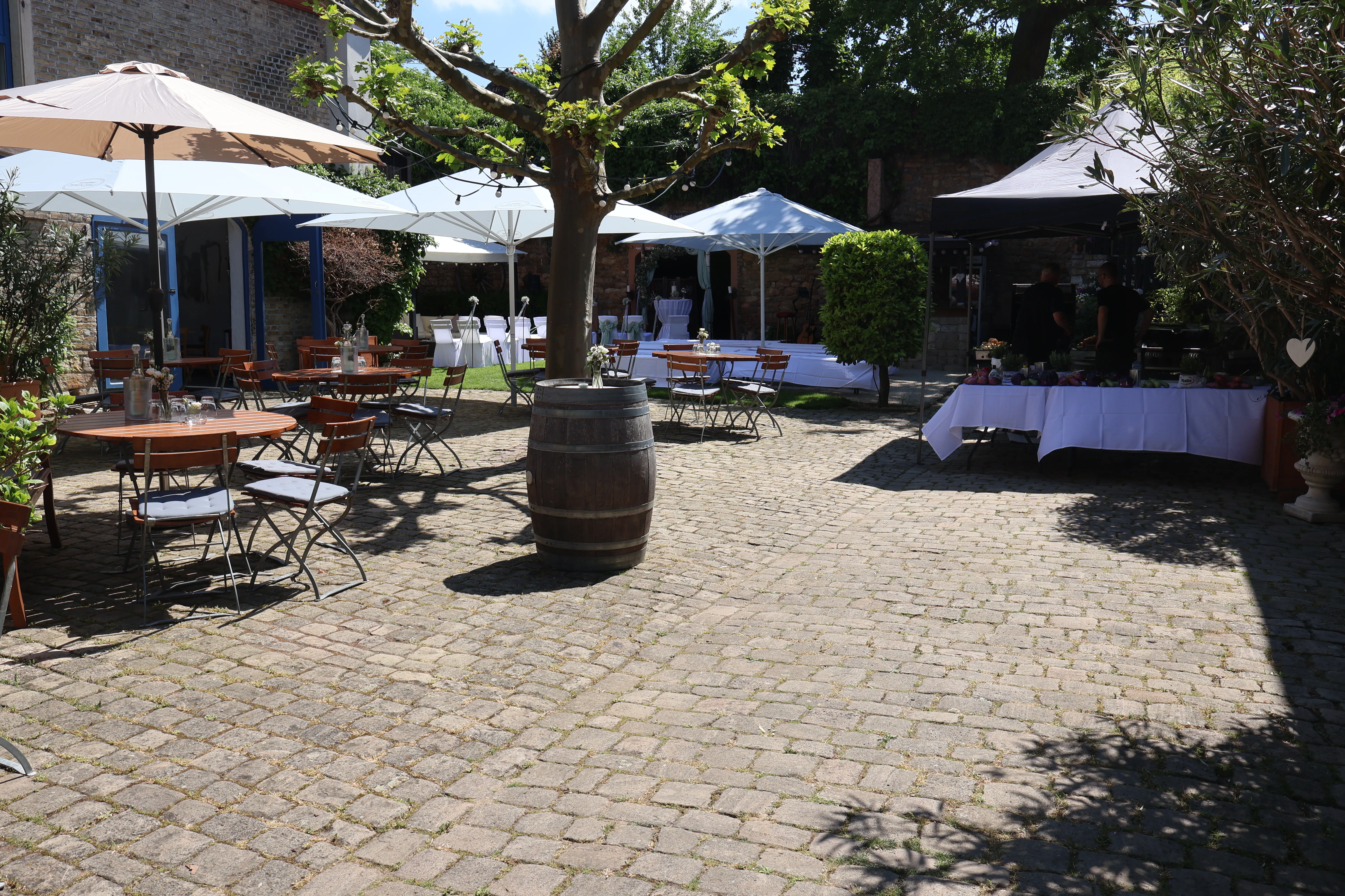 Sektempfang im Innenhof von Wagners Hof Undenheim mit Sonnenschirmen und Weinfass