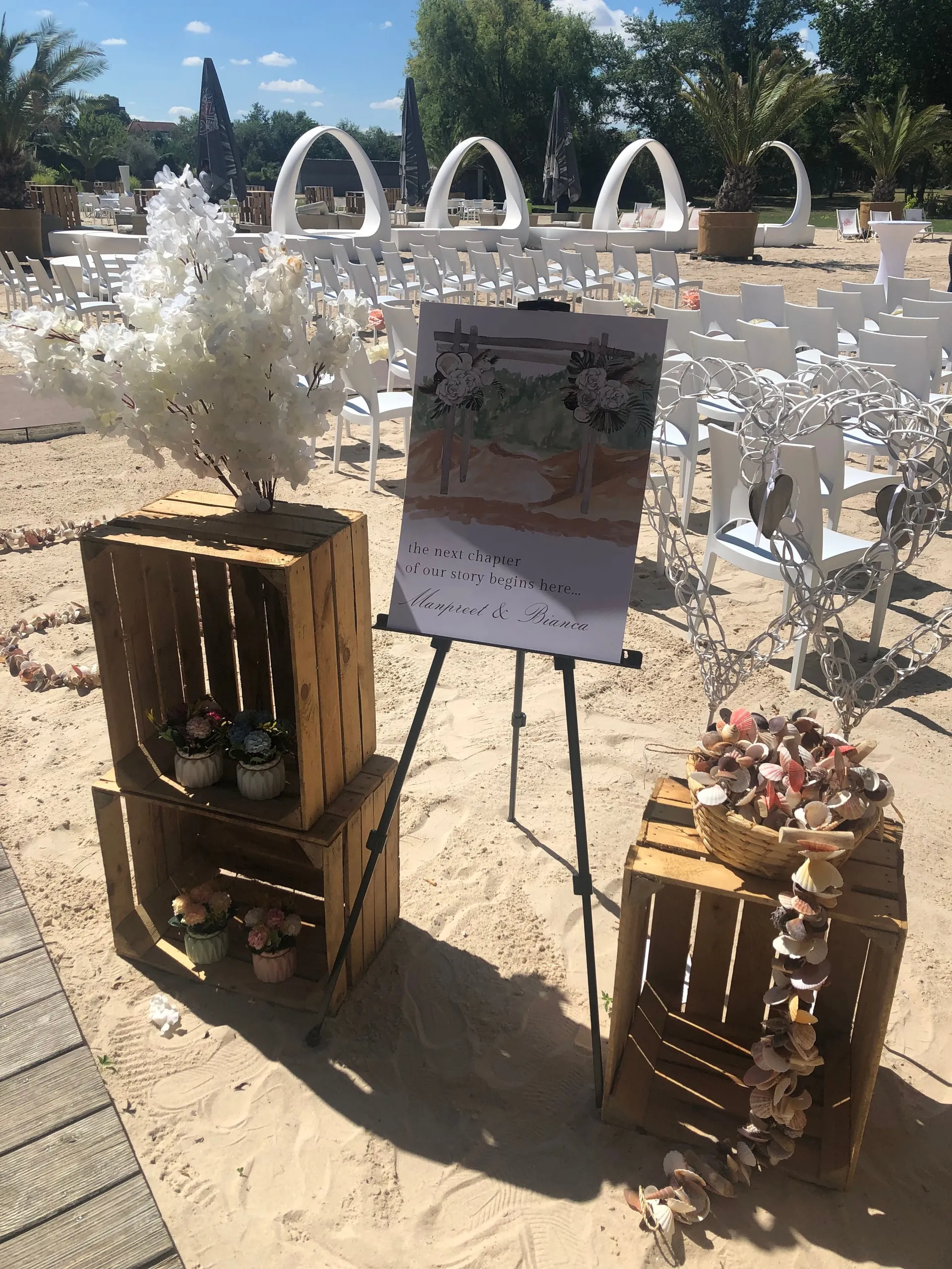 Willkommensschild mit Foto auf einer Staffelei bei einer Strandhochzeit